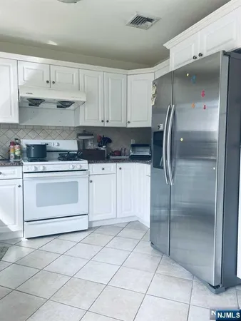 a kitchen with white cabinets and white appliances