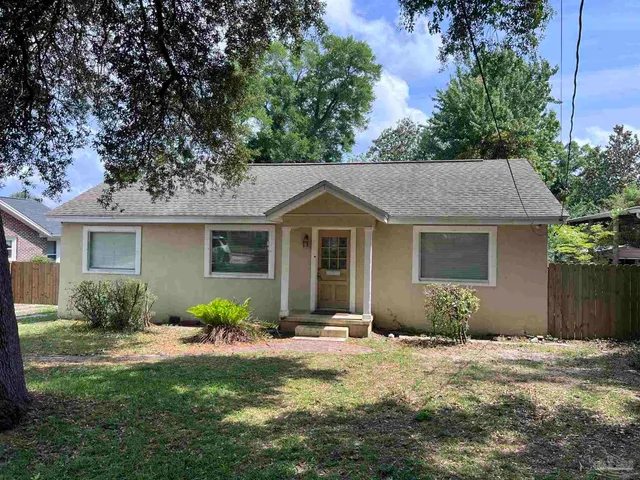 a front view of a house with a yard and potted plants