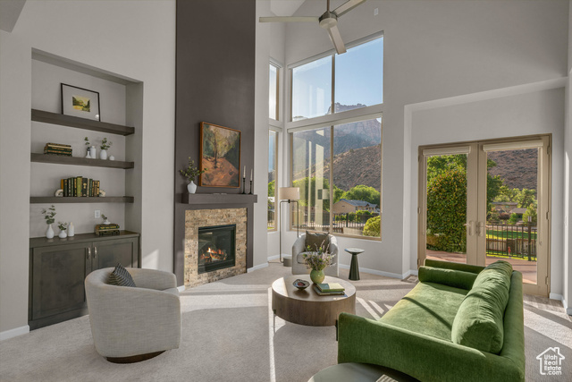 101 Chuckwalla Lane Springdale, UT 84767 - Photo 20 of 51 Living room with a high ceiling, carpet floors, built in features, a stone fireplace, and a mountain view