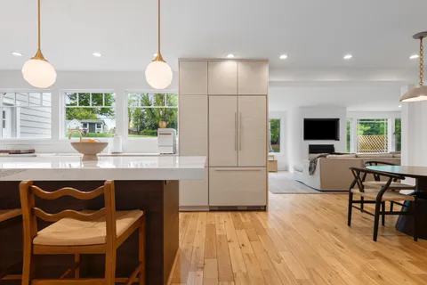 a kitchen with a table chairs sink and cabinets