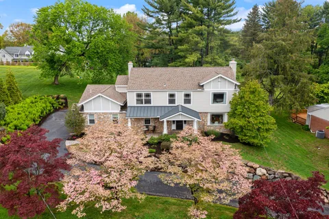 an aerial view of residential house with outdoor space and trees all around