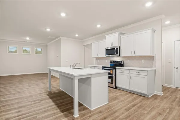 a kitchen with a sink stainless steel appliances and white cabinets