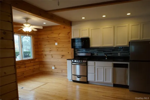 a kitchen with stainless steel appliances kitchen island granite countertop a stove a sink and a microwave