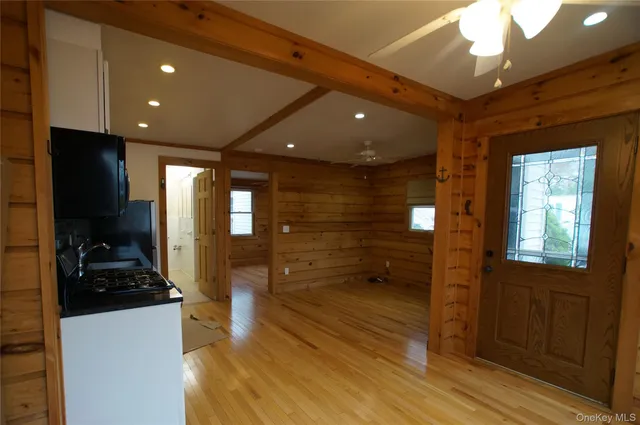a view of a hallway with wooden floor and livingroom with furniture