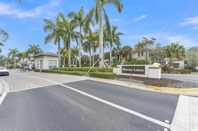 a front view of a house with a yard and palm trees