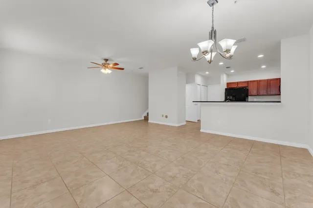 a view of a big room with chandelier fan and kitchen view