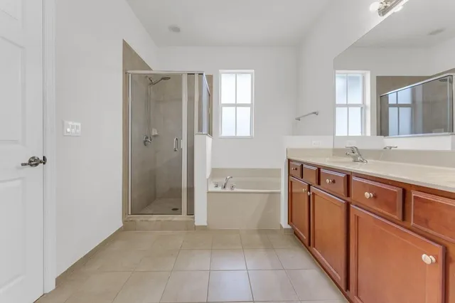 a spacious bathroom with a granite countertop sink a mirror and a bathtub