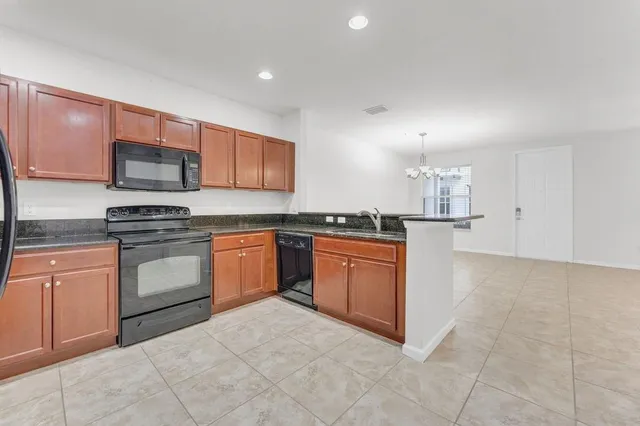 a kitchen with stainless steel appliances granite countertop a stove top oven a sink and dishwasher