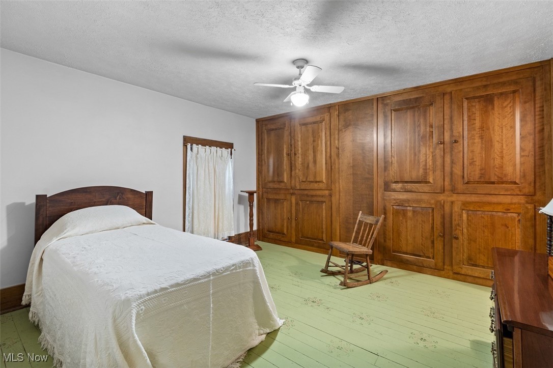 13642 Navarre Road Southwest Beach City, OH 44608 - Photo 22 of 33 Bedroom with light hardwood / wood-style flooring, ceiling fan, and a textured ceiling