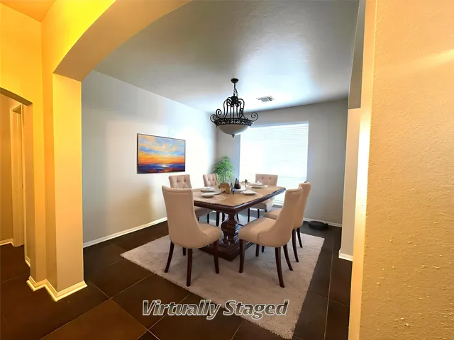 a view of a dining room with furniture and a chandelier