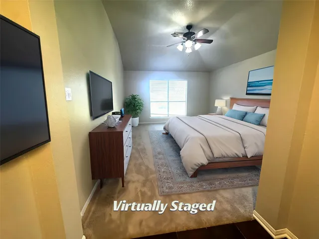 a spacious bedroom with a bed and a flat screen tv