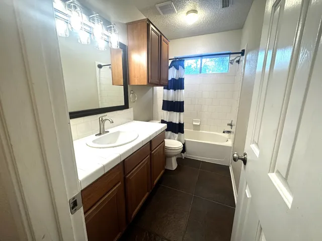 a bathroom with a double vanity sink toilet and shower