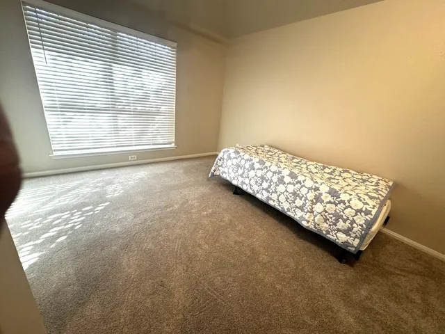 a bed sitting in a bedroom next to a window