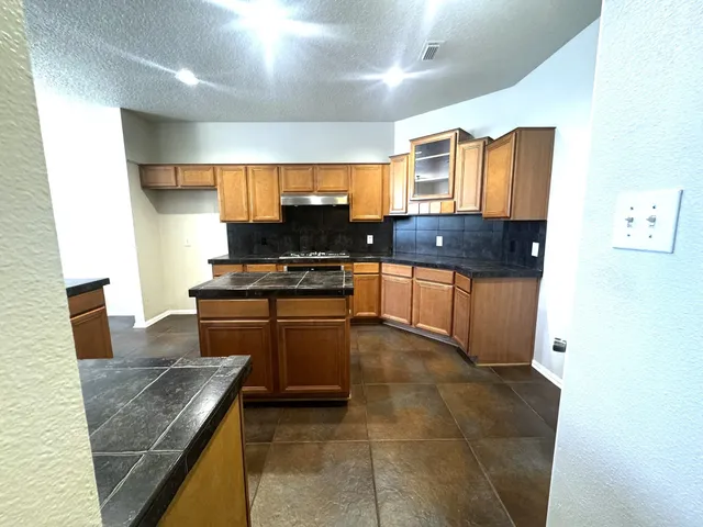 a kitchen with stainless steel appliances granite countertop a sink and a stove