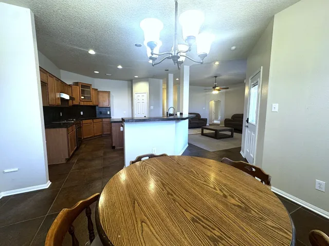 a large kitchen with kitchen island a stove a sink a refrigerator and a dining table