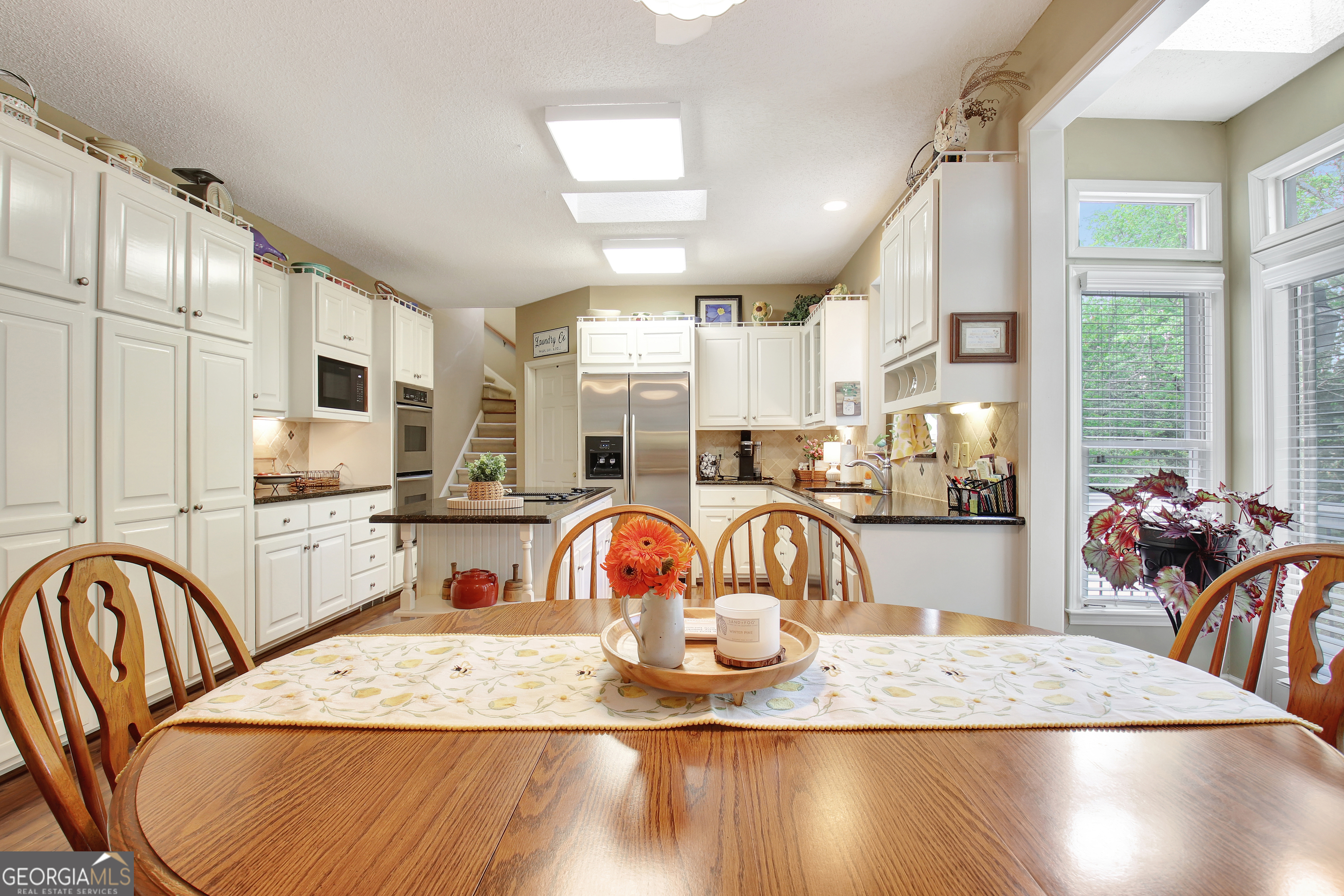 110 Sunset Court Senoia, GA 30276 - Photo 35 of 118 a kitchen with stainless steel appliances granite countertop a sink a table and chairs