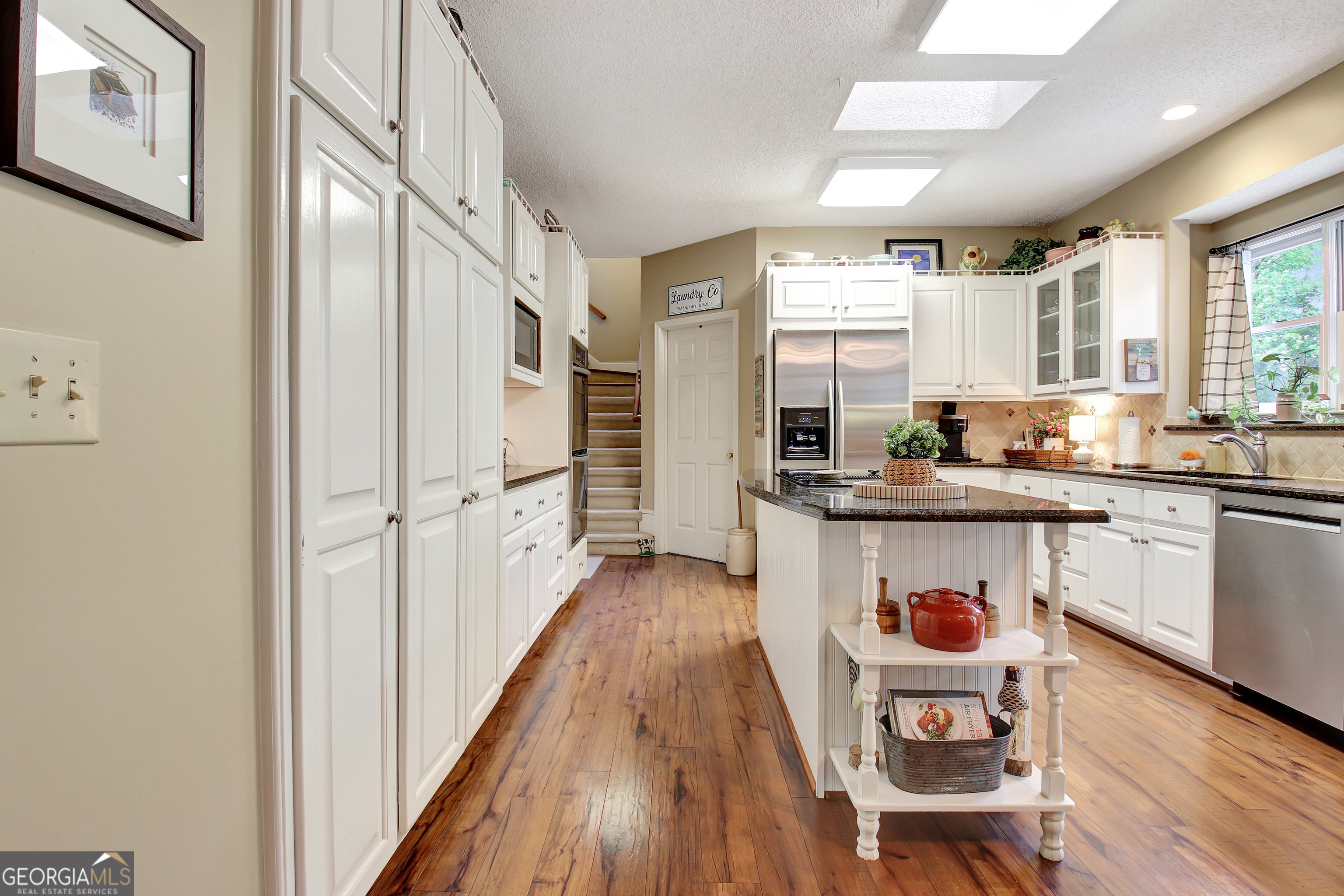 110 Sunset Court Senoia, GA 30276 - Photo 36 of 118 a kitchen with stainless steel appliances granite countertop a refrigerator a sink dishwasher a stove and white countertops with wooden floor