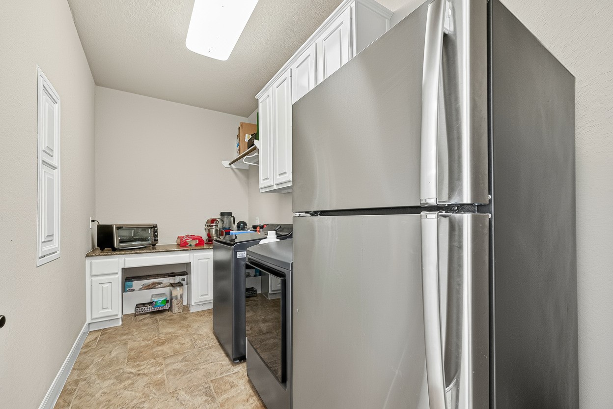 1206 Coleridge Street Sugar Land, TX 77479 - Photo 21 of 46 Convenient secondary kitchen with additional refrigerator, washer, and dryer (included). Ideal for heavy cooking, meal prep, or extra storage.