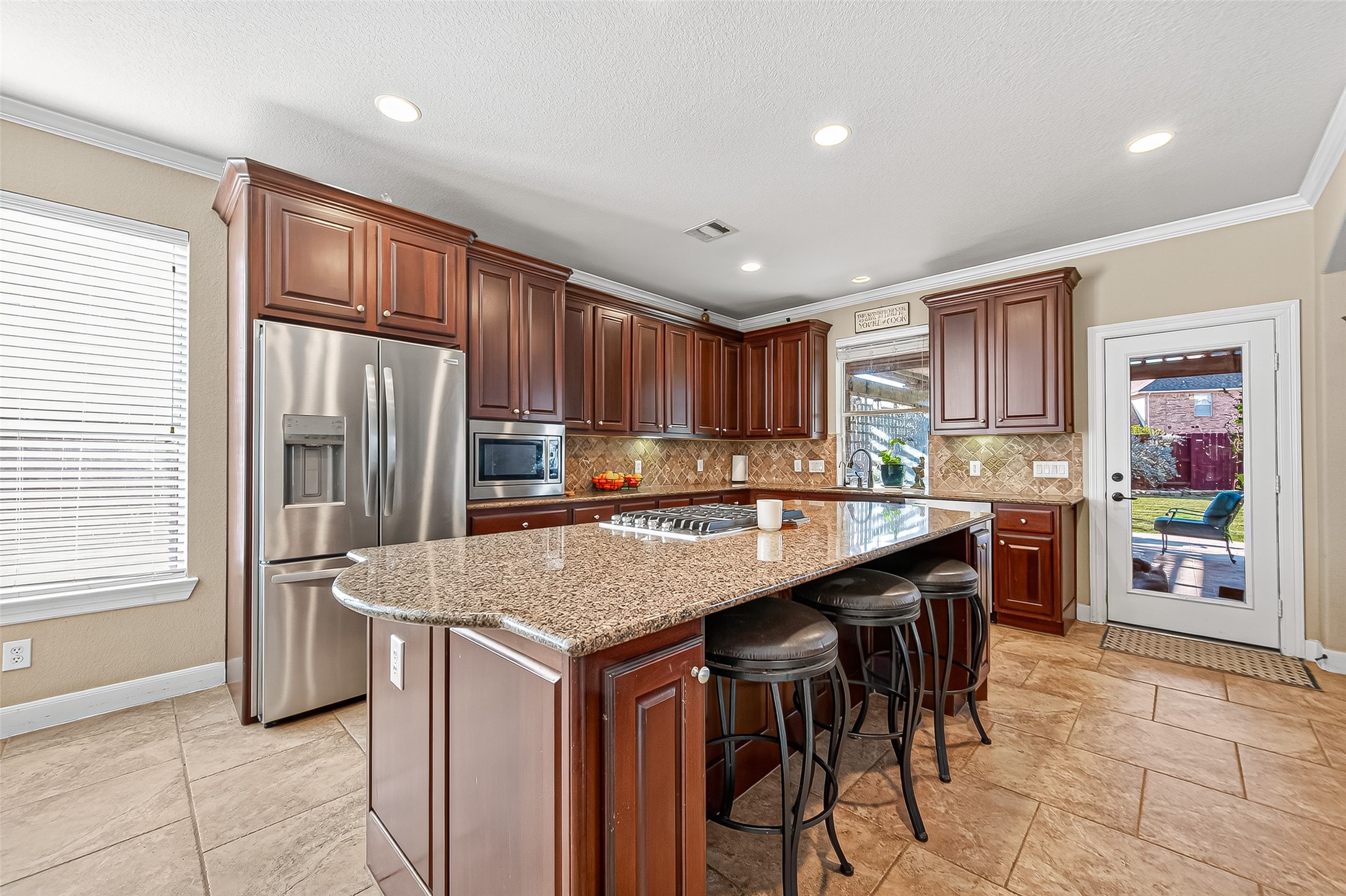 1206 Coleridge Street Sugar Land, TX 77479 - Photo 25 of 46 a kitchen with stainless steel appliances granite countertop a table chairs sink refrigerator and cabinets