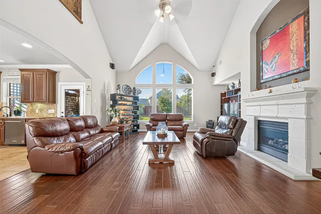 a view of a livingroom with furniture a ceiling fan and wooden floor