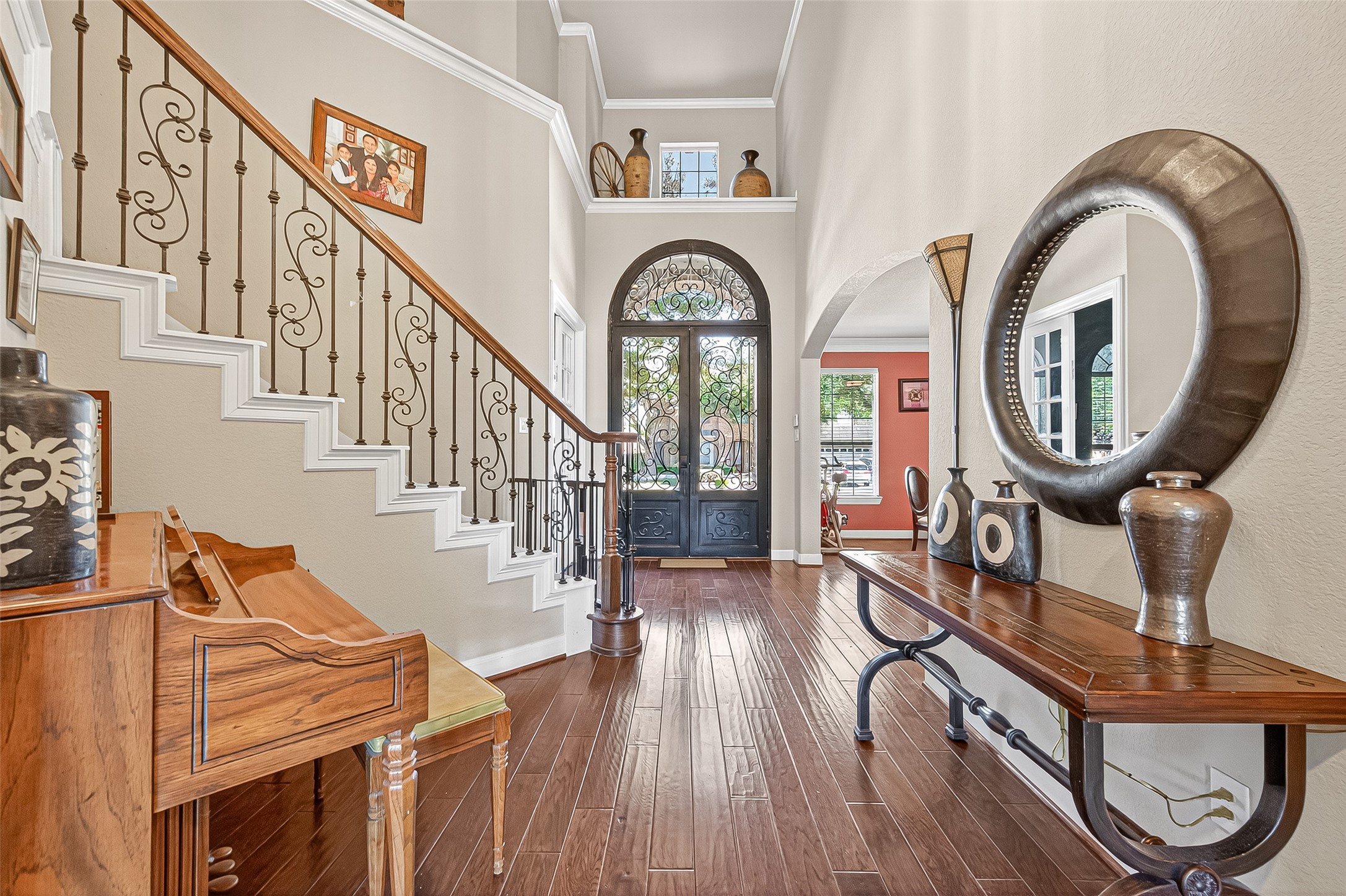 1206 Coleridge Street Sugar Land, TX 77479 - Photo 7 of 46 Elegant entryway featuring hardwood floors, a decorative staircase with wrought-iron railings, and soaring ceilings.