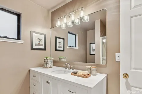 a bathroom with a sink vanity and a mirror