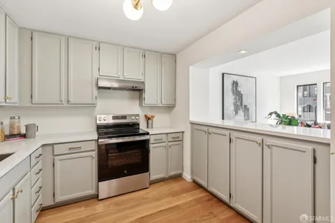 a kitchen with white cabinets and appliances