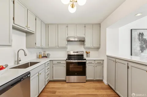 a kitchen with a stove top oven sink and cabinets