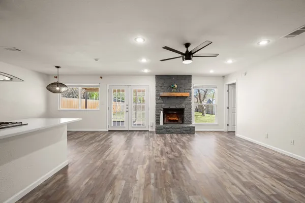 an empty room with wooden floor a fireplace and a window