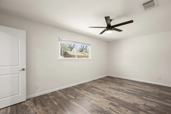 a view of empty room with wooden floor