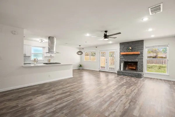 a large kitchen with cabinets wooden floor and a fireplace