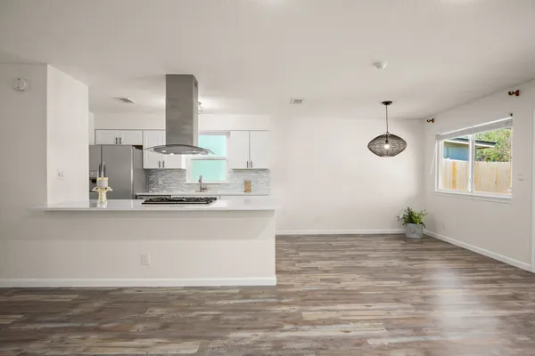 a kitchen with granite countertop a stove cabinets and wooden floor