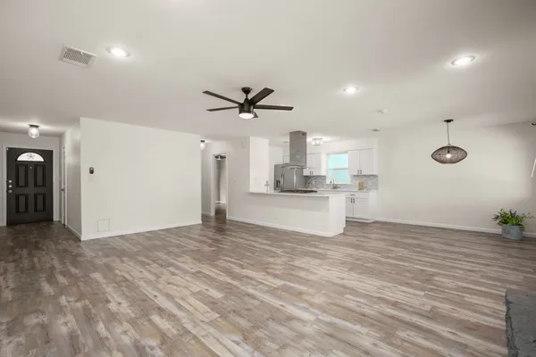 a view of empty room with wooden floor and ceiling fan