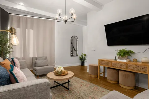 a view of a hallway with wooden floor and windows