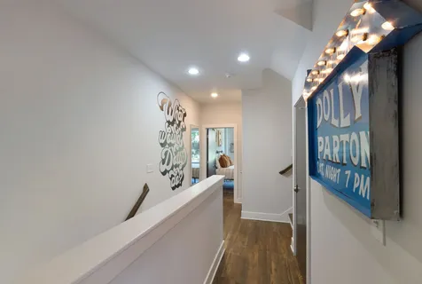 a view of a hallway with wooden floor and stairs