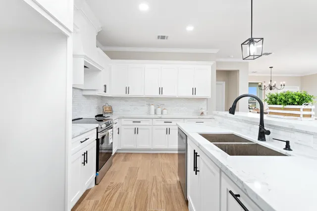 a kitchen with a sink a stove and cabinets