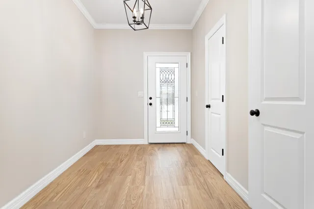 a view of a room with wooden floor and door