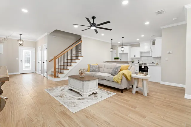 a living room with furniture and a wooden floor