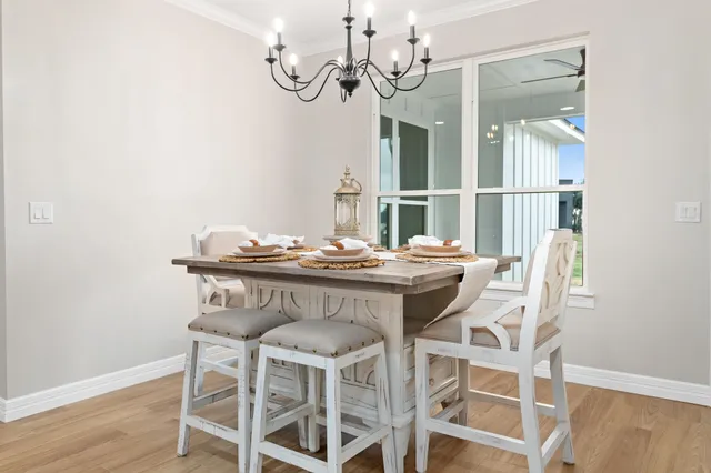 a dining room with furniture a chandelier and wooden floor