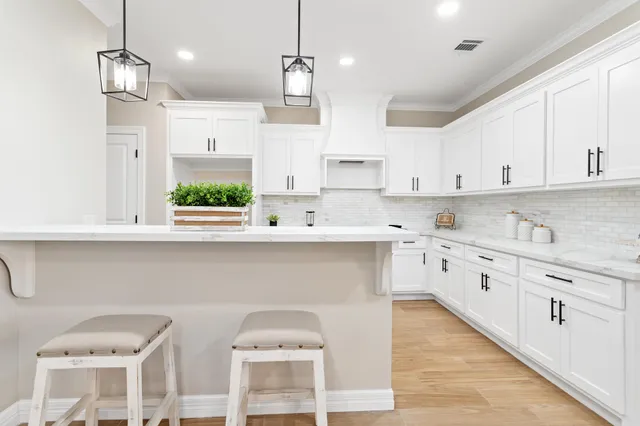 a kitchen with stainless steel appliances kitchen island granite countertop a sink a stove a dining table and chairs