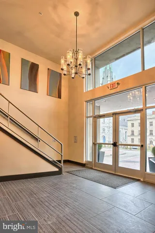 a view of kitchen with stainless steel appliances wooden floor and living room view