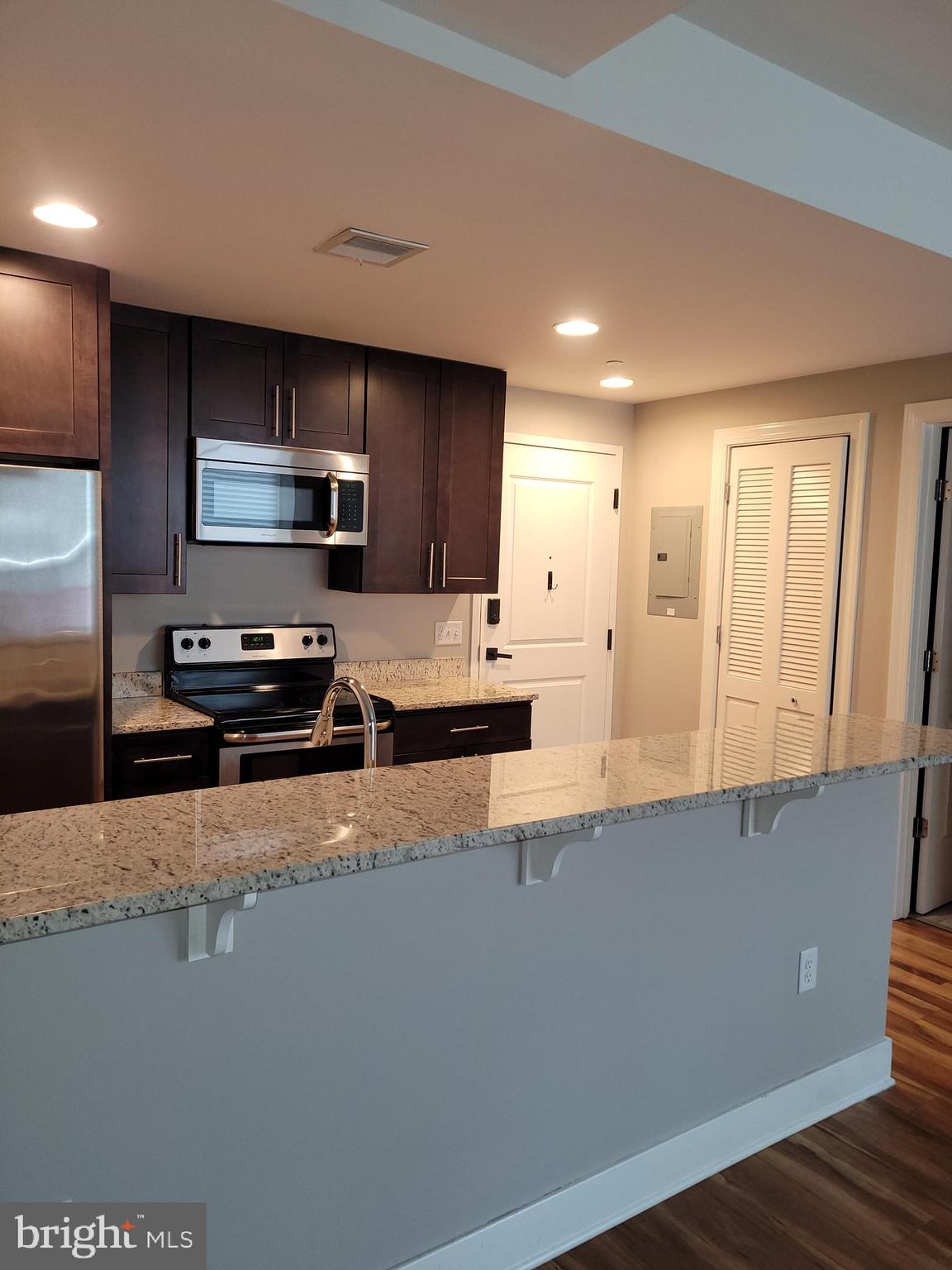 231 State Street, Unit 406 Harrisburg, PA 17101 - Photo 6 of 22 a large kitchen with a large counter top stainless steel appliances and cabinets