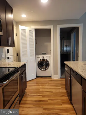 a kitchen with stainless steel appliances granite countertop a sink a stove and refrigerator