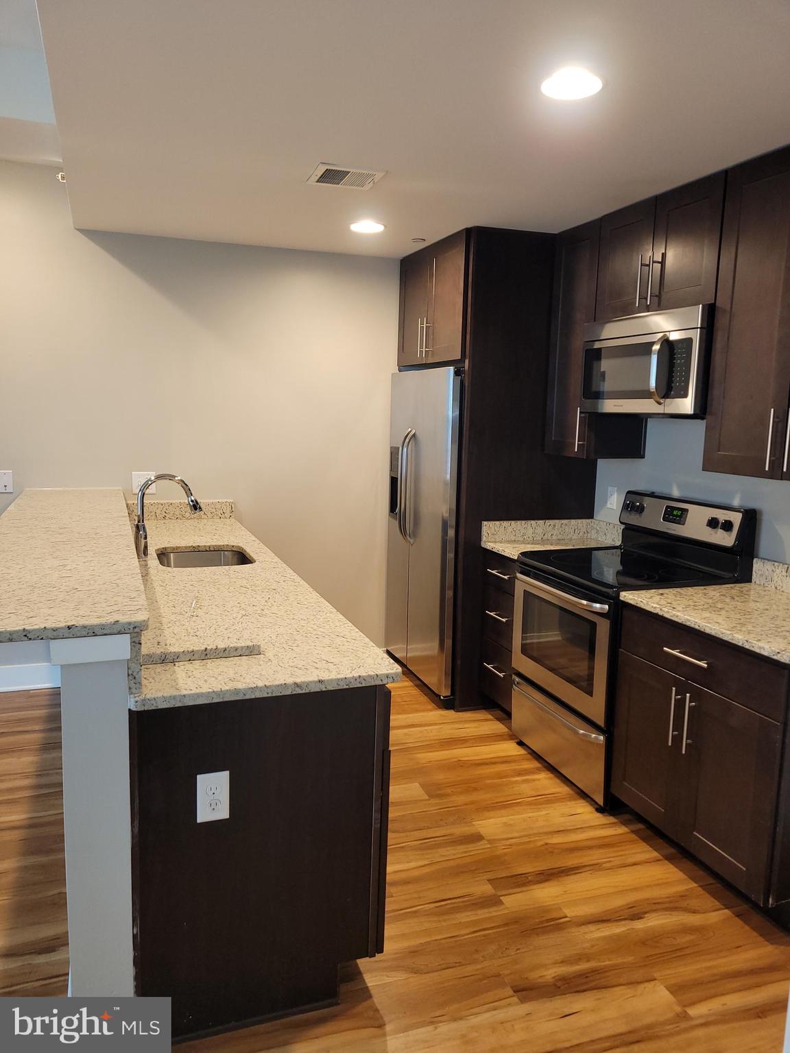 231 State Street, Unit 406 Harrisburg, PA 17101 - Photo 9 of 22 a kitchen with stainless steel appliances granite countertop a sink a stove and refrigerator
