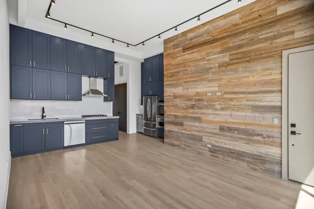a kitchen with stainless steel appliances cabinets and wooden floor