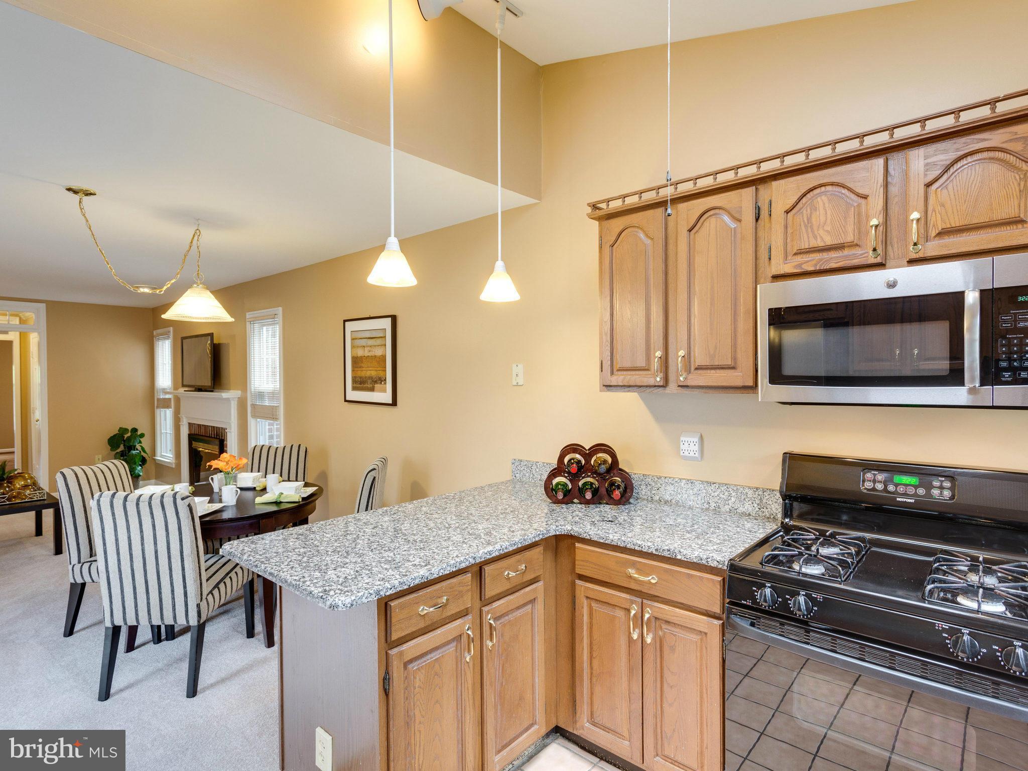 6564 Forsythia Street Springfield, VA 22150 - Photo 14 of 30 a kitchen with stainless steel appliances granite countertop a stove a sink and a microwave