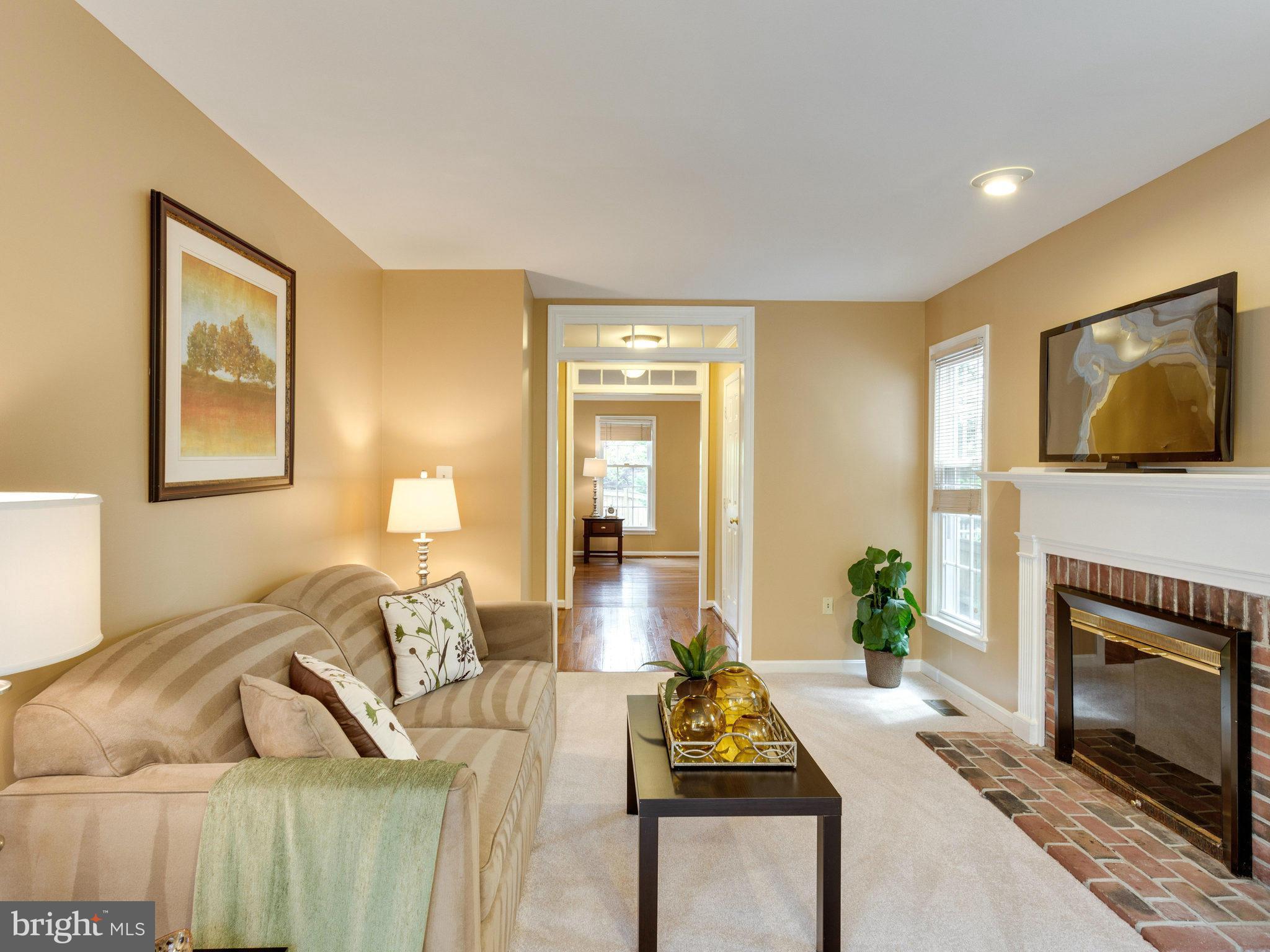 6564 Forsythia Street Springfield, VA 22150 - Photo 10 of 30 a living room with furniture a flat screen tv and a fireplace