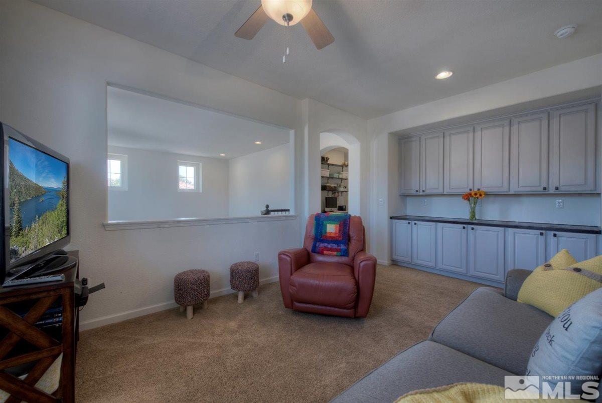 431 Shire Court Reno, NV 89521 - Photo 22 of 40 a living room with furniture a projector and a bookshelf