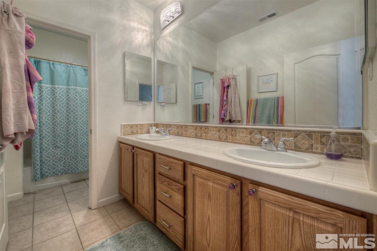 431 Shire Court Reno, NV 89521 - Photo 24 of 40 a bathroom with a granite countertop sink and a mirror