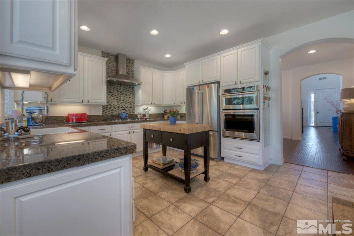 431 Shire Court Reno, NV 89521 - Photo 4 of 40 a kitchen with stainless steel appliances granite countertop a sink and a refrigerator